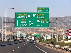 Interchange advance guide road signs with Greek text in yellow and English text in white.