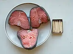 Three dried salmon steaks, pink interiors with skin still on.