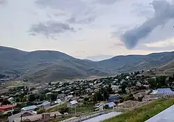 The picture is a panorama of Lernavan depicting a small town in a hilly landscape.
