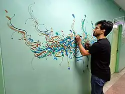 A calligrapher at work on the school wall