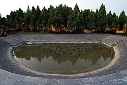 The half-moon pool, submerged "doors", and wooded burial mound