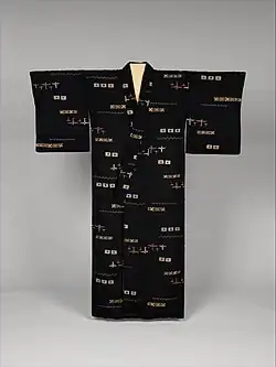 Front view of a women's indigo kimono with a woven ikat pattern in white, cream and brown.