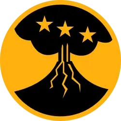 On a yellow disk 3 1/4 inches in diameter with a 1/8 inch edge, a conventionalized black volcano emitting smoke, the volcano charged with three yellow mullets in fess
