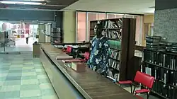 This is an image of a librarian standing up to attend to a user in the Library