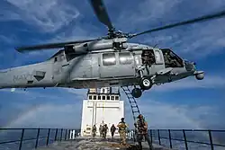 An MH-60S of HSC-85 picks up Navy SEALs from the deck of ATLS-9701 during an exercise, 2022