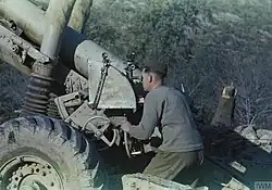 A British gunner uses the dial sight and range scale plate of a 5.5-inch gun in 1944.