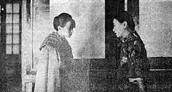 A black-and-white image of two women facing each other