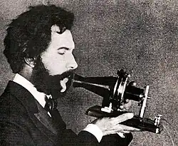 Image 75Actor portraying Alexander Graham Bell in a 1932 silent film. Shows Bell's second telephone transmitter (microphone), invented 1876 and first displayed at the Centennial Exposition, Philadelphia. (from History of the telephone)