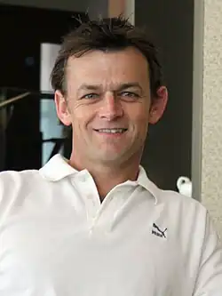 Picture of Gilchrist wearing a white collared T-shirt