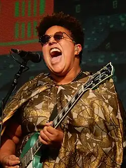 Brittany Howard playing guitar and singing into a microphone