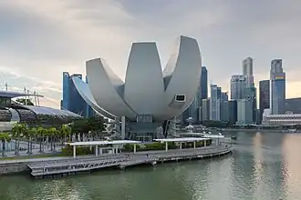 A lotus-inspired building designed by Moshie Safdie that features 10 "fingers" anchored by a unique round base in the middle.