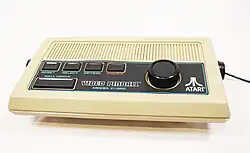 Atari Video Pinball games console model C-380 cream colored. Image shows a white plastic case with five buttons and a dial. The buttons are labelled reset, select, option, power and "ball serve".