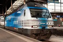 An Re 460 awaits departure with a domestic long-distance train.