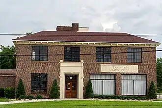 Two-story brick building with Coca-Cola themed panel