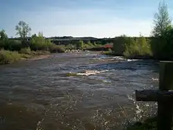 A midsized river flowing through shrub land