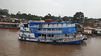 A passenger boat (Ze Alberto 2013) docked at the town
