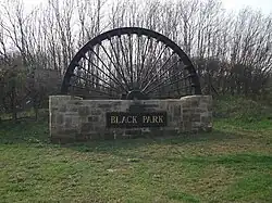 Colliery wheel welcome village sign for Black Park (near Chirk)