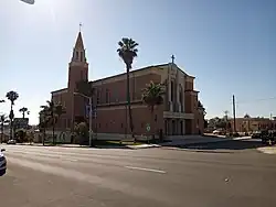 Blessed Sacrament Catholic Church: College Area Business District signs hang from the streetlight in front.