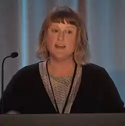 Close up portrait of Briar Levit standing in front of a podium