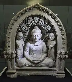 Group of Buddha seated between two monks, with two quasi-Corinthian pilasters that are here because of the influence of Greek culture during the Hellenistic period, 1st-3rd centuries, stone, State Museum of History of Uzbekistan, Tashkent