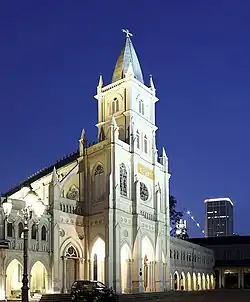 A white, lit up church stands against a night sky