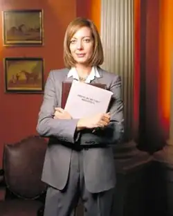Allison Janney, pictured in costume as C. J. Cregg, for a promotional shoot