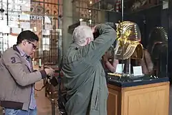 Tourist photographing Tutankhamun's golden burial mask display