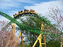 One of the Cheetah Hunt trains is photographed traversing over a bunny hill. In the opposite direction is another track section before the heartline roll.