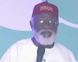 Chukwuemeka Ezeife wearing a traditional cap, speaking with a microphone