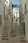 A typical street in the old town, narrow, with white facades and exterior stairs