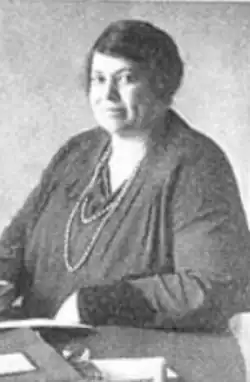 Clara Burrill Bruce, from a 1929 publication; a Black woman, seated at a desk, wearing a dark blouse or dress