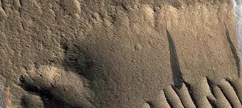 Close view of dark slope streaks on wall of trough as seen by HiRISE under HiWish program. The image is about 1 km across.
