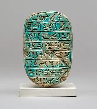 The back of a commemorative scarab of Amenhotep III, recording a lion hunt; 1390–1352 BC; blue glazed steatite; length: 8 cm; Metropolitan Museum of Art