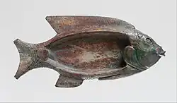 Cosmetic dish in the shape of a tilapia fish; 1479–1425 BC; glazed steatite; 8.6 cm × 18.1 cm (3.4 in × 7.1 in); Metropolitan Museum of Art