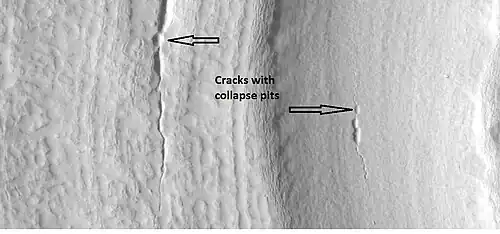 Close-up showing cracks containing pits on the floor of a crater containing concentric crater fill, as seen by HiRISE under the HiWish program. Location is the Casius quadrangle.