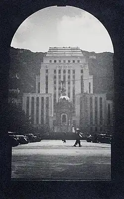 A black and white photo shows a statue of Queen Victoria in front of the HSBC Building, Hong Kong in the 1930s.