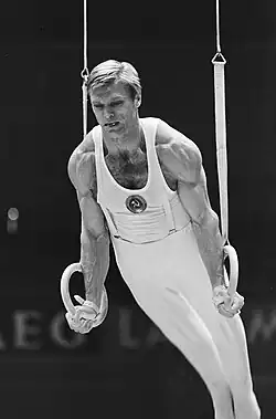 Boris Shakhlin straining while competing on the hanging rings. Picture is in black and white.