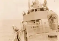 Crewmen peer over the side of Dione to pick up survivors of a shipwreck