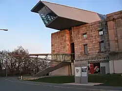 Documentation Center; with its "glass and steel arrow", piercing the north wing, the Documentation Center is supposed to be a widely visible architectural counterpoint.[4]