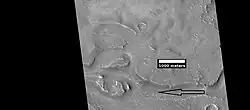 Close view of streamlined shapes, as seen by HiRISE under HiWish program Arrow indicates the direction of past flowing water.