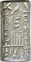 Small cylinder of grey silver with hieroglyphic signs inscribed on it