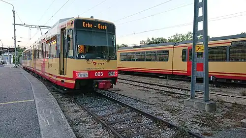 Yellow train next to railway tracks