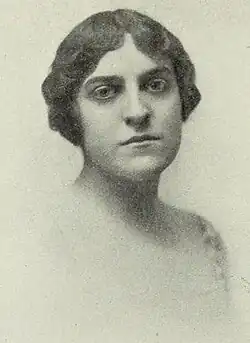 A young white woman with short dark wavy hair.