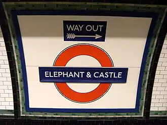 A London Underground "roundel" reads "Elephant and Castle." A smaller sign says "Way Out" above it.