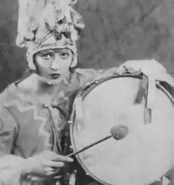 Ethel Shutta, wearing a costume and posed with a drum and drumstick