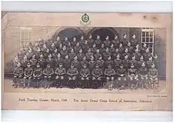 Formal picture of approx 50 males in Army Uniform, front row seated, with the officers, then 4 rows standing probably on benches or staging, about 15 per row, presumably of dentists who were passing out following completion of the course