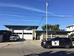 A fire station with an American flag and a police SUV in front