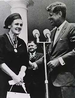 Black-and-white photo of a smiling Kelsey meeting with President John F. Kennedy; the medal for the President's Award for Distinguished Federal Civilian Service hangs around Kelsey's neck