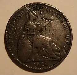 Copper coin of a seated woman Britannia, with letters stamped on it