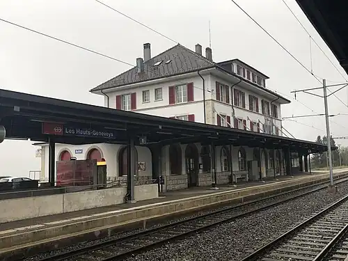 Three-story building with hip roof and adjoining canopy-covered shelter